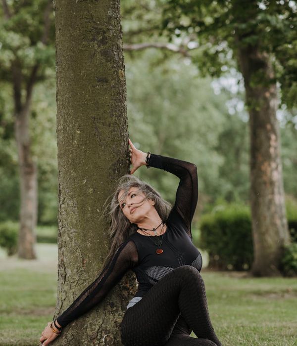Woman sitting in a calm meditation pose with glowing green energy lines around her.